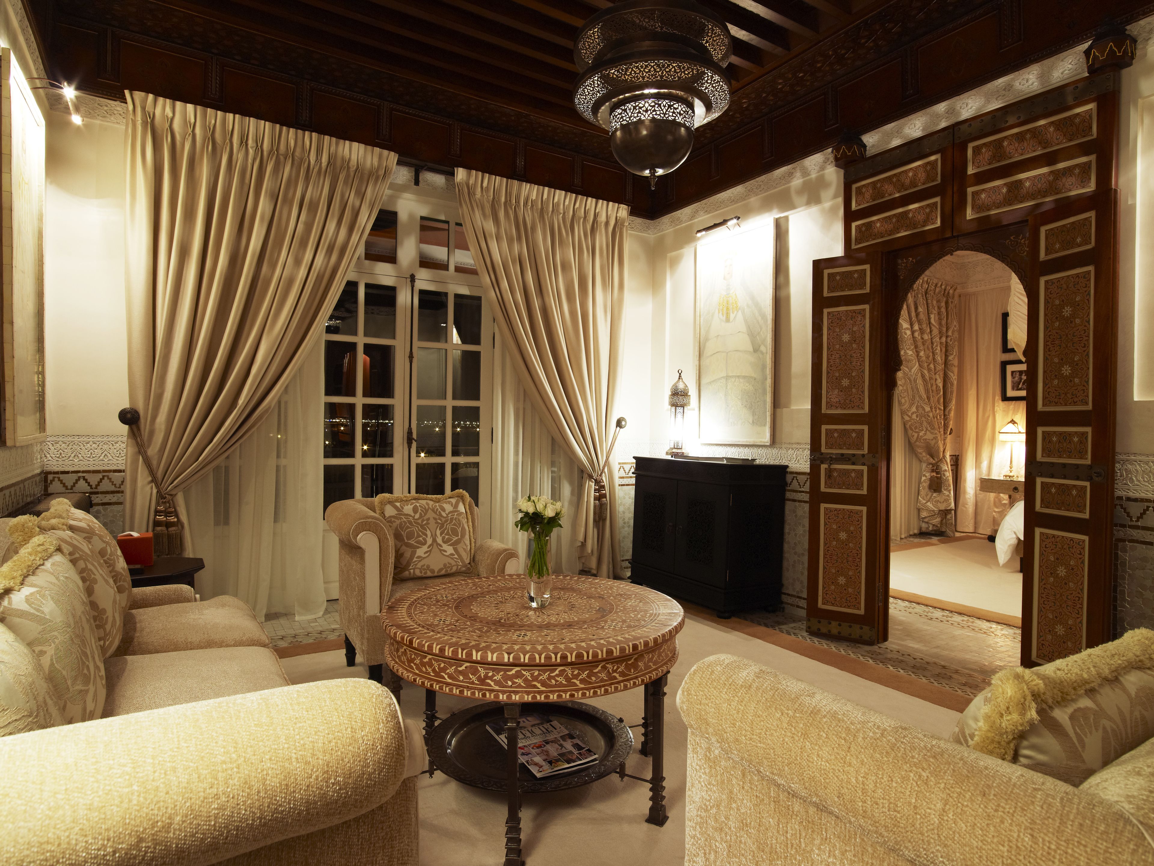 A traditional room with a fireplace, a round coffee table, and a sofa.