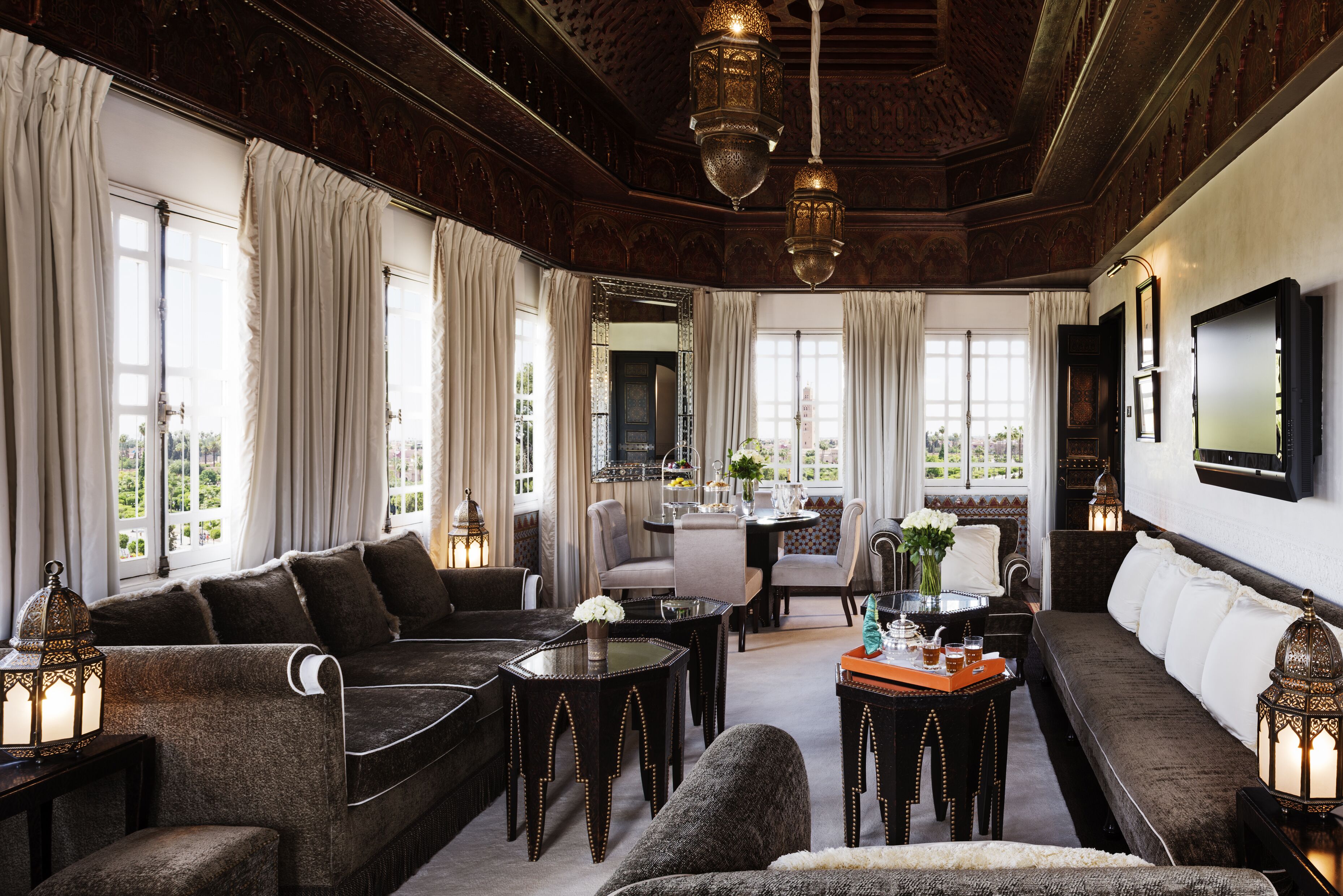 A spacious living room with a sofa, armchairs, a coffee table, and a dining area.