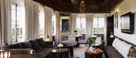 Un salon spacieux comprenant un canapé, des fauteuils, une table basse et un coin repas.
