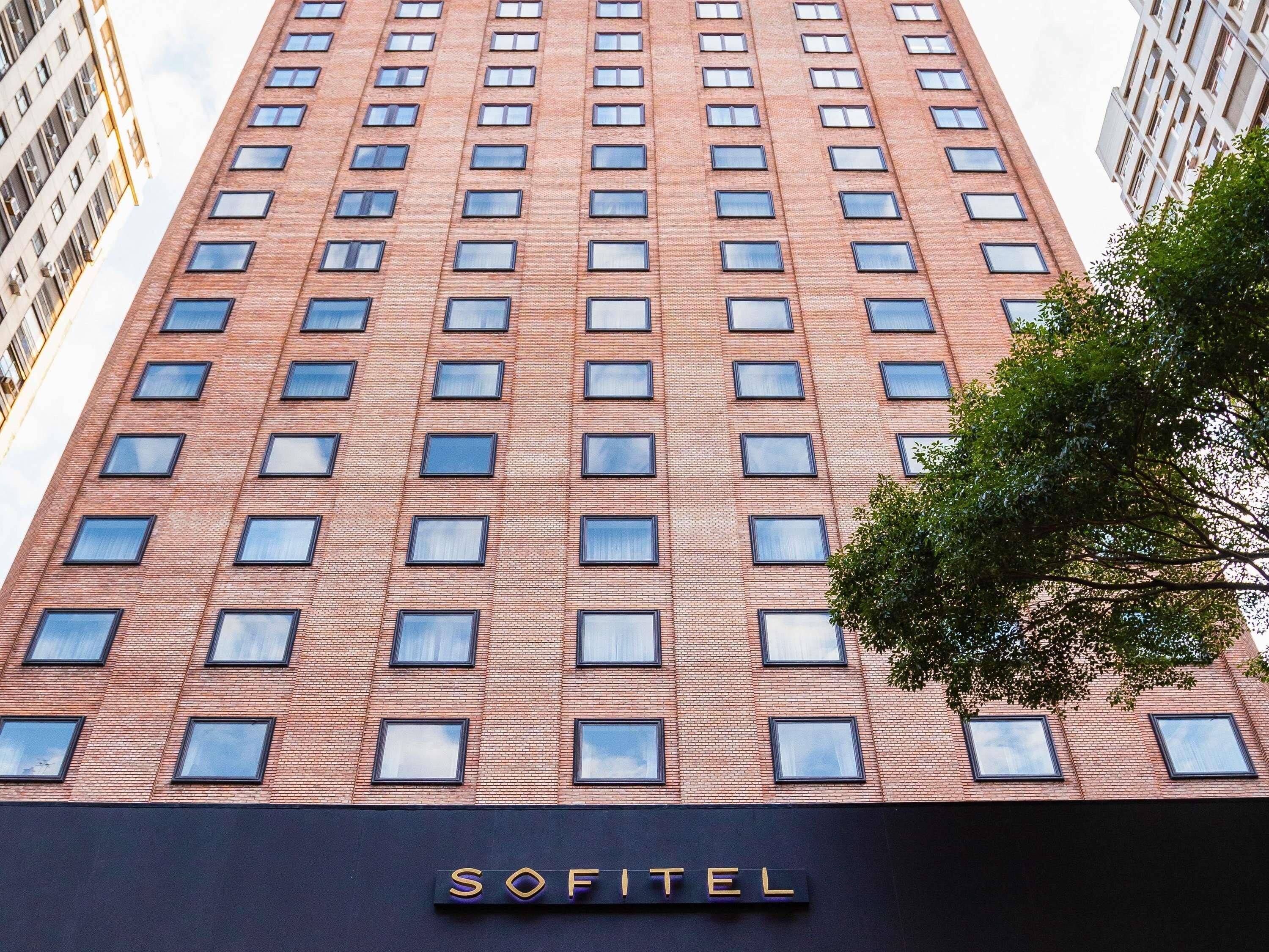 Un edificio alto in mattoni con un cartello che riporta la scritta 'SOFITEL' nella parte inferiore.