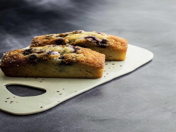 Two muffins on a white plate with a textured edge.