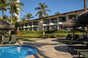 A hotel with a pool area, lounge chairs, and palm trees. - Transamerica Resort Comandatuba – All Inclusive (Una)
