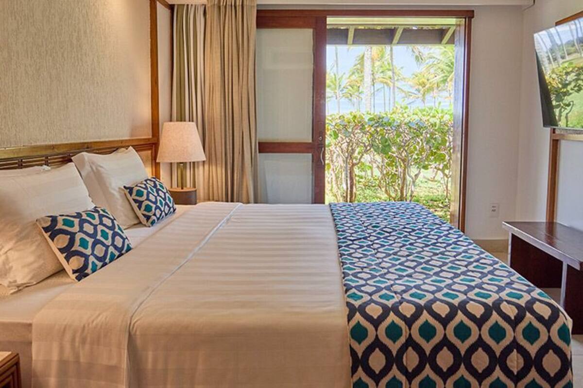 Une chambre d’hôtel avec un grand lit, une télévision et une vue sur l’extérieur.
