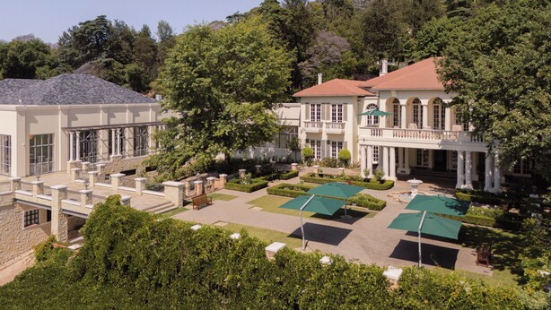 A large, two-story building with a courtyard, surrounded by trees and featuring a red-tiled roof. - Four Seasons Hotel The Westcliff, Johannesburg (Randburg)
