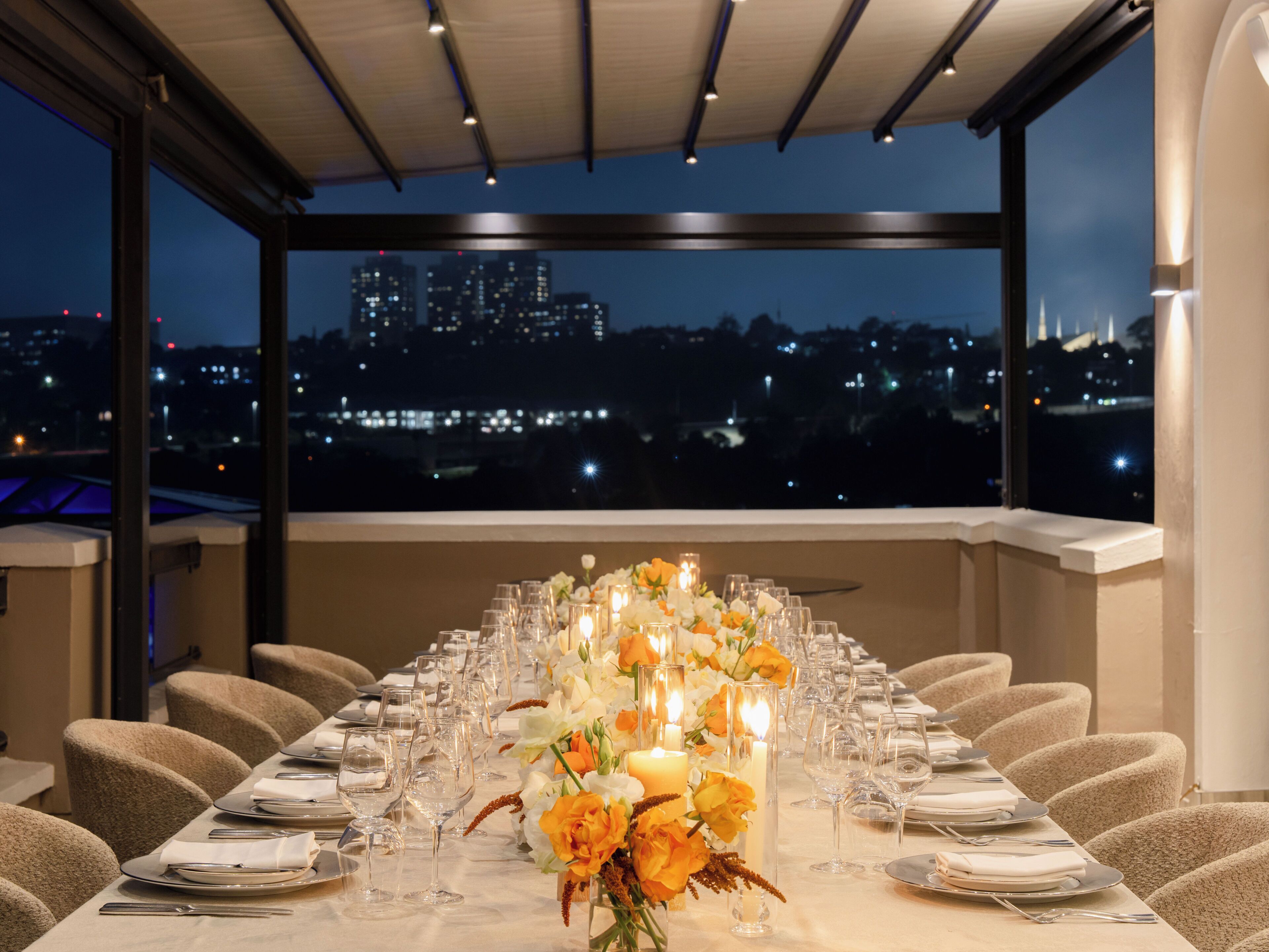 Mesa de jantar posta para refeição com vista para a cidade.