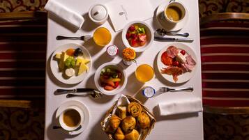 Een ontbijtsetting met diverse gerechten, waaronder fruit, gebak en drankjes, op een tafel gerangschikt.