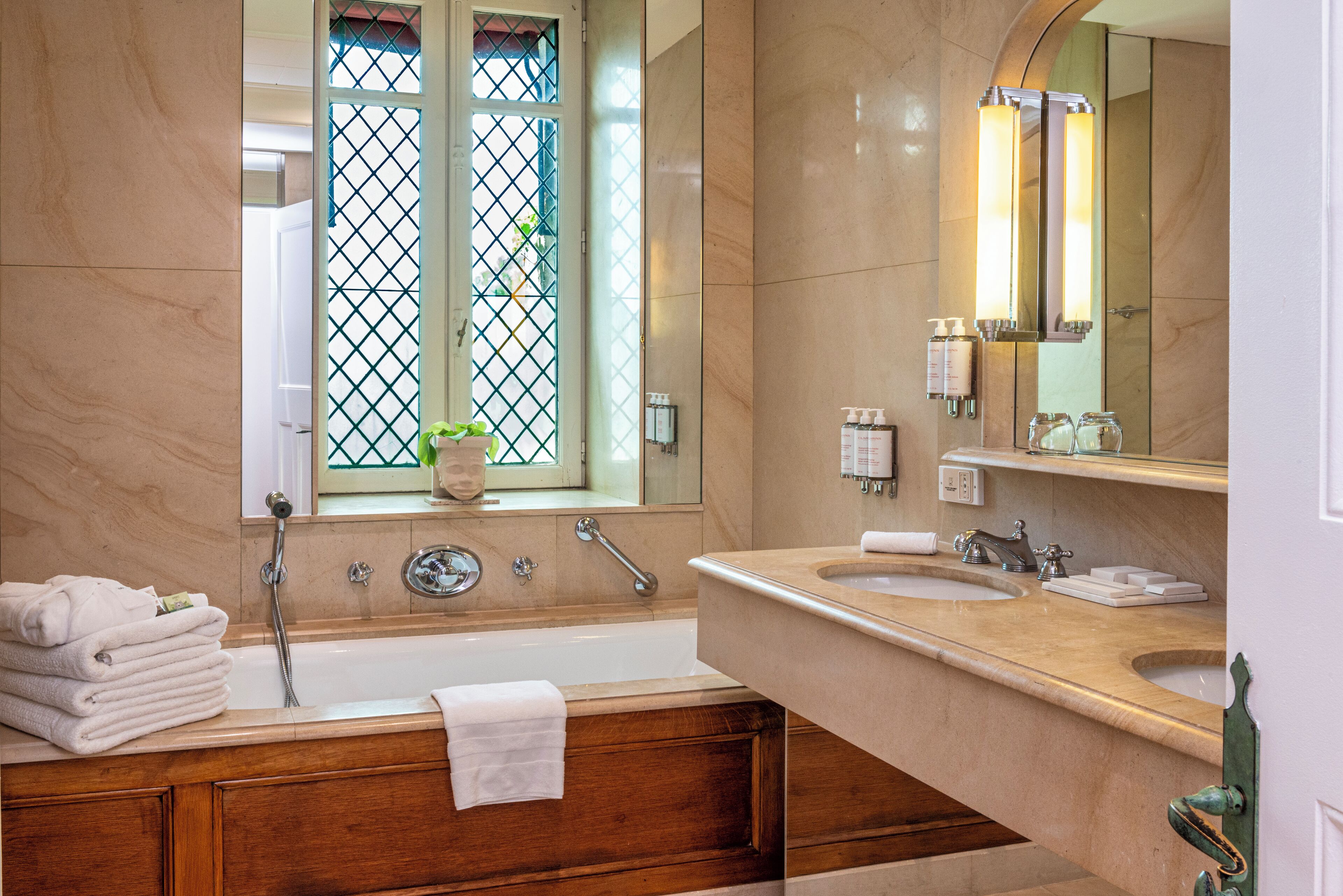 A modern bathroom with a large bathtub, two sinks, and a vanity with a mirror.