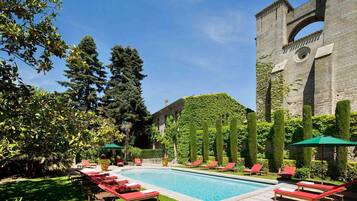 Una piscina al aire libre de temporada, sombrillas