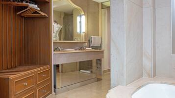 A modern bathroom with a wooden vanity, a large mirror, a bathtub, and a glass shower enclosure.