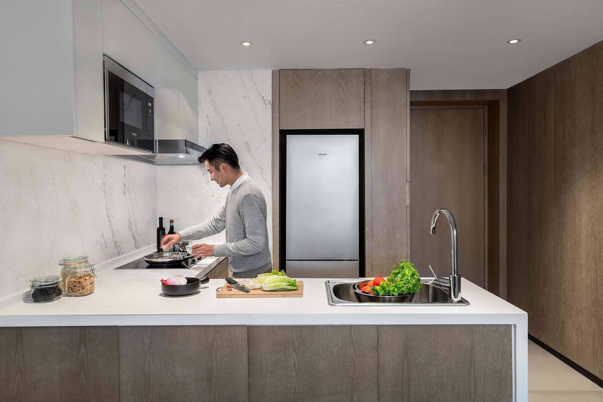 Eine moderne Küche mit einer zentralen Kochinsel, integrierten Geräten und einem eleganten Design.