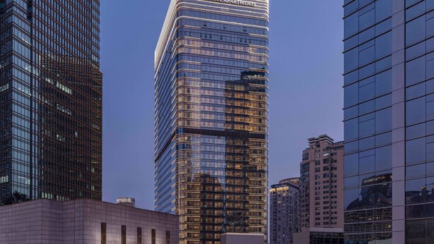 Um edifício alto com fachada de vidro moderna e o logotipo Marriott Executive Apartments.