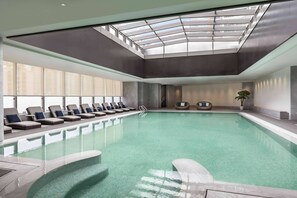 Relax by the pool surrounded by comfortable lounge chairs and a serene atmosphere.