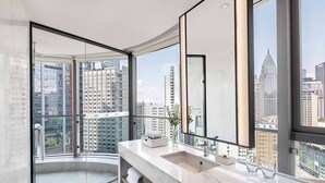 Un baño moderno con un amplio ventanal, un lavabo y un espejo.