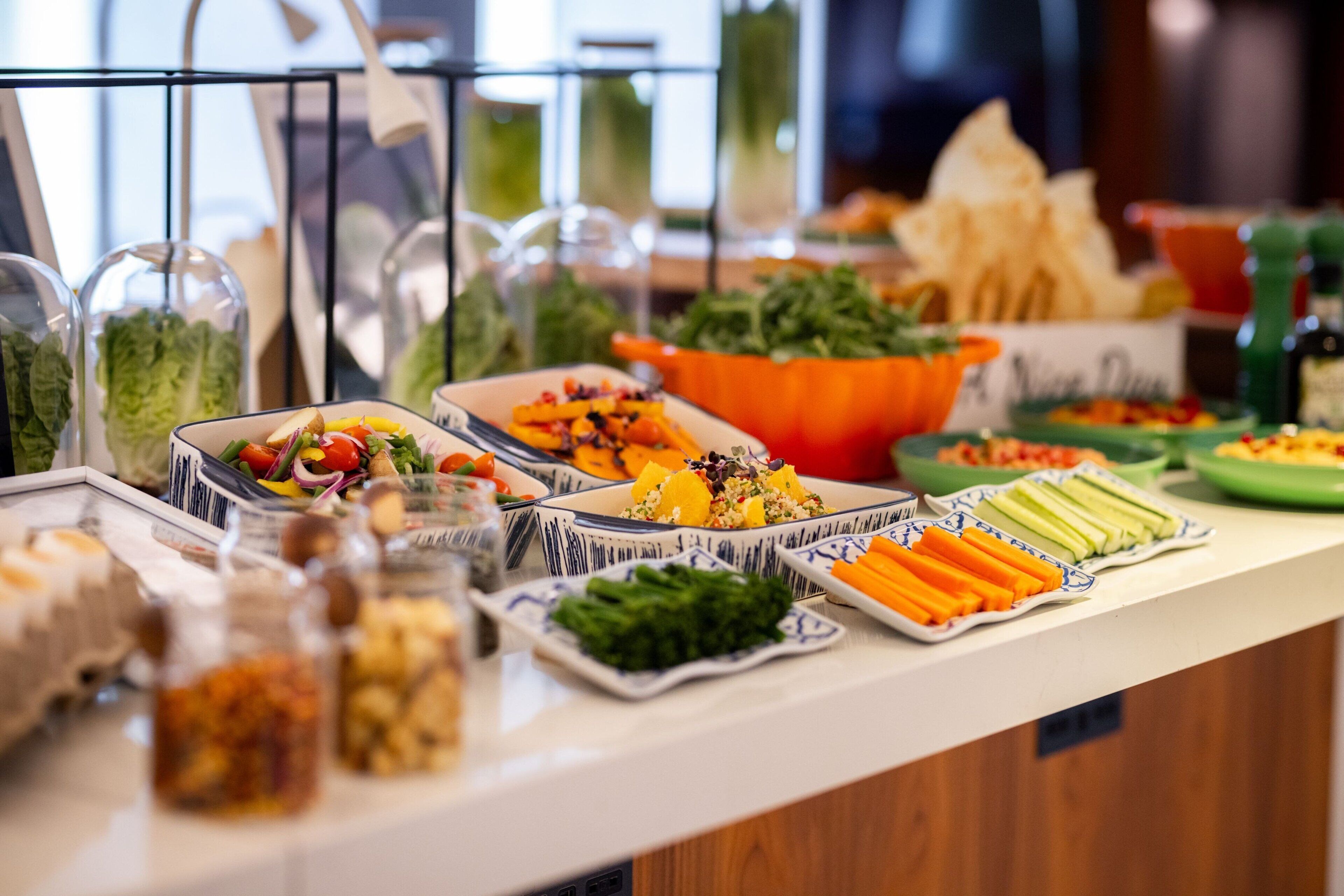 A buffet with various dishes including salads, vegetables, and other food items.