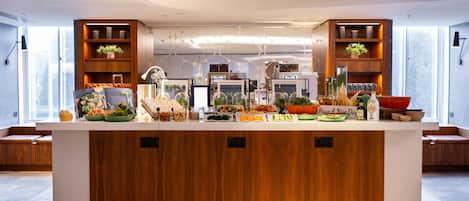 Une cuisine moderne dotée d’un îlot central, de meubles en bois et de divers produits alimentaires exposés sur le plan de travail.