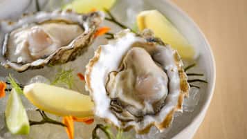 A plate of oysters on ice with garnishes.