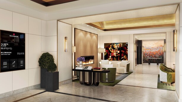 A modern hotel lobby with a digital display, seating area, artwork, and a fireplace. - Millennium Premier Hotel New York Times Square (New York)