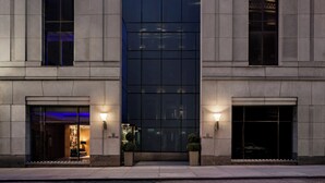 A modern building with a glass facade, large windows, and a symmetrical design. - Millennium Premier Hotel New York Times Square (New York)