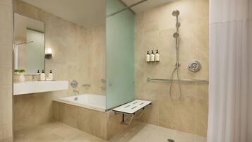 A modern bathroom with a bathtub, a shower, and a vanity with a mirror.