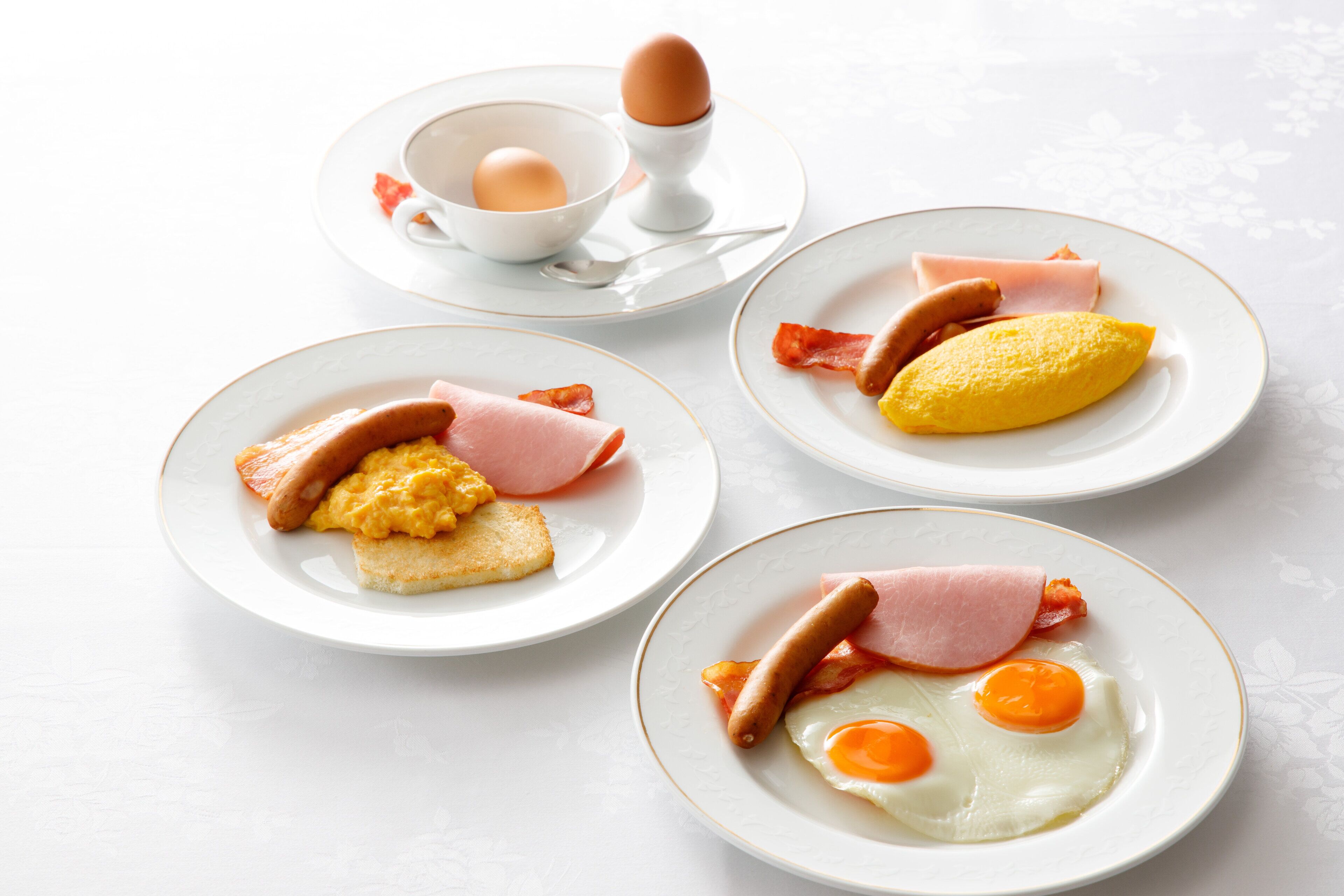 Tres platos de comida para el desayuno sobre una mesa.