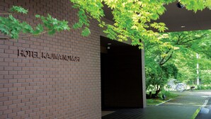 Entrada de un hotel con fachada de ladrillo y un cartel que dice "HOTEL KAIMANOMORI".