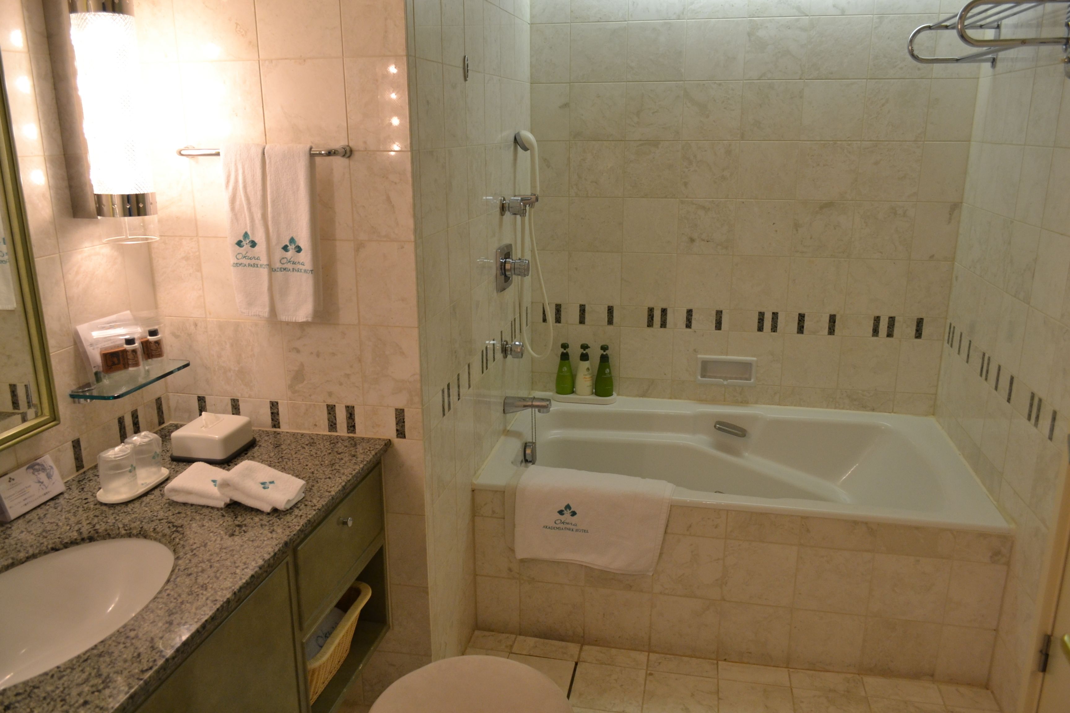 A bathroom with a sink, mirror, towel rack, shower, and bathtub.