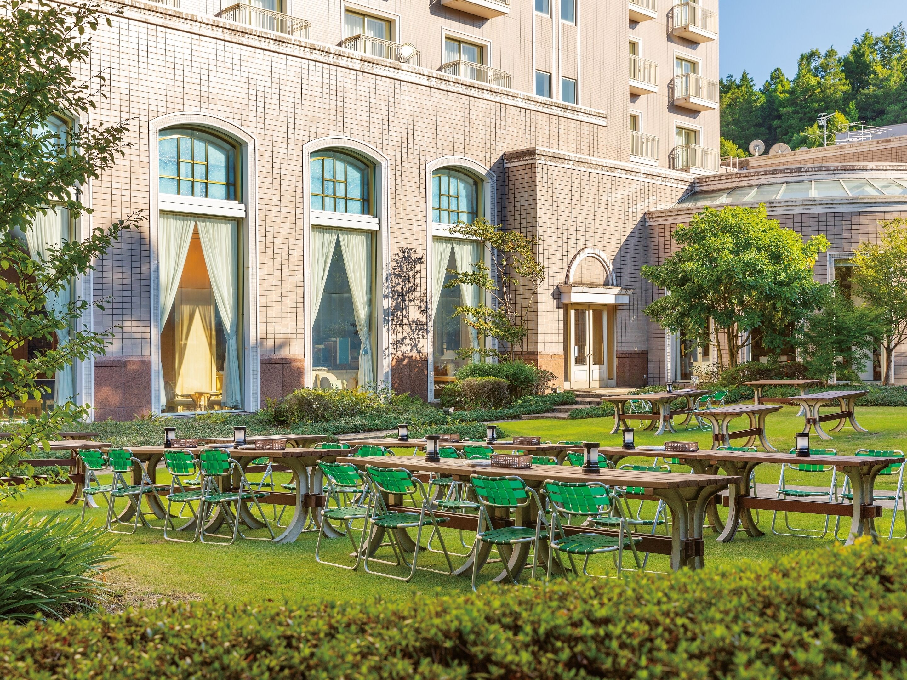A courtyard with outdoor seating and a building with large windows and a brick facade.