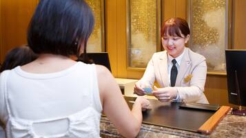 A reception desk with a receptionist and a guest.
