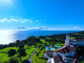 A coastal property with a large ocean view, a swimming pool, and a golf course.