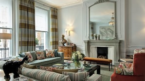 A traditional living room with a sofa, armchair, fireplace, and decorative items. - Brown's Hotel, a Rocco Forte Hotel (London)
