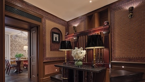 A lobby with a marble reception desk, two standing lamps, a vase of white flowers, and a patterned wall. - Brown's Hotel, a Rocco Forte Hotel (London)