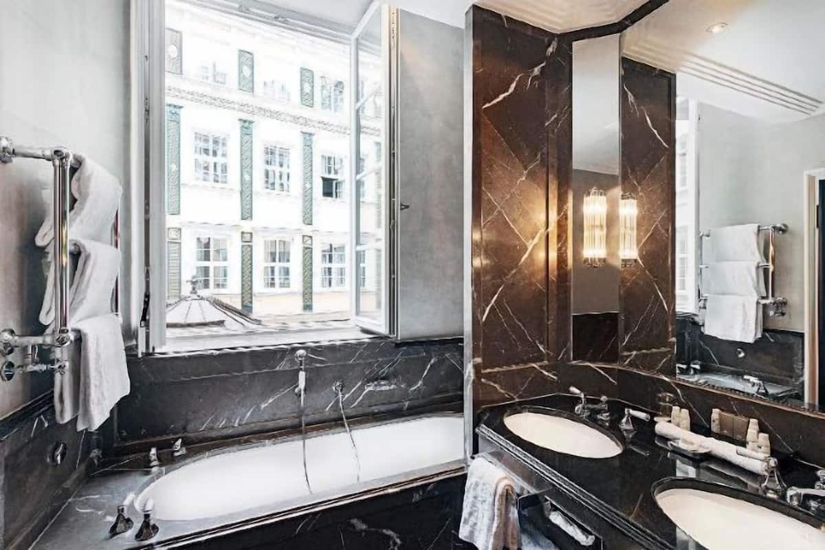 Badkamer | Een bad/douchecombinatie, een regendouche, designer toiletartikelen