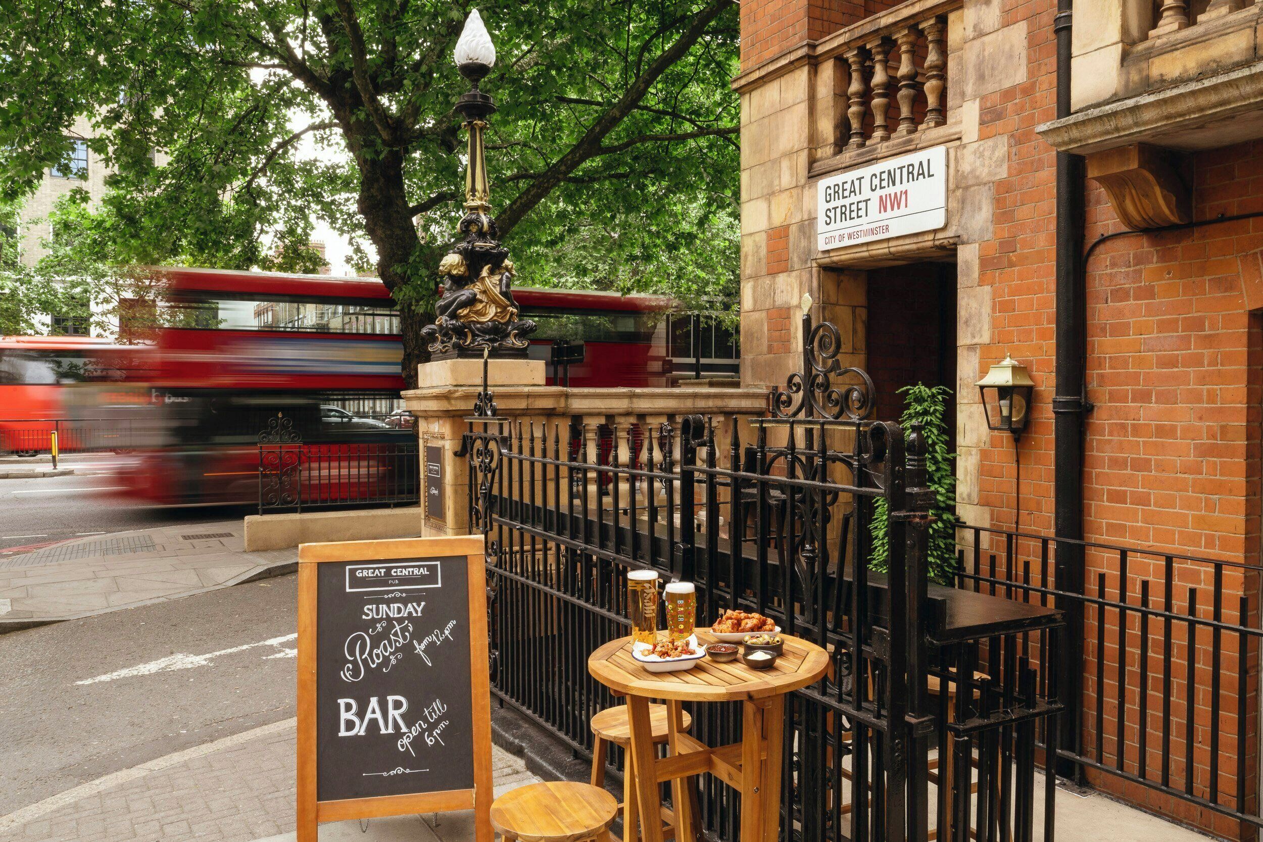Un pub appelé « Great Central », avec des tables à l’extérieur, une pancarte indiquant « Rôti du dimanche, 18 h », et un autobus à deux étages rouge en arrière-plan.