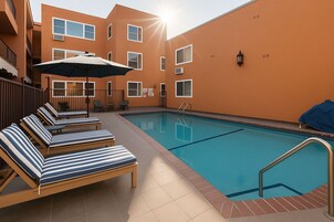 Una piscina al aire libre, sillones reclinables de piscina