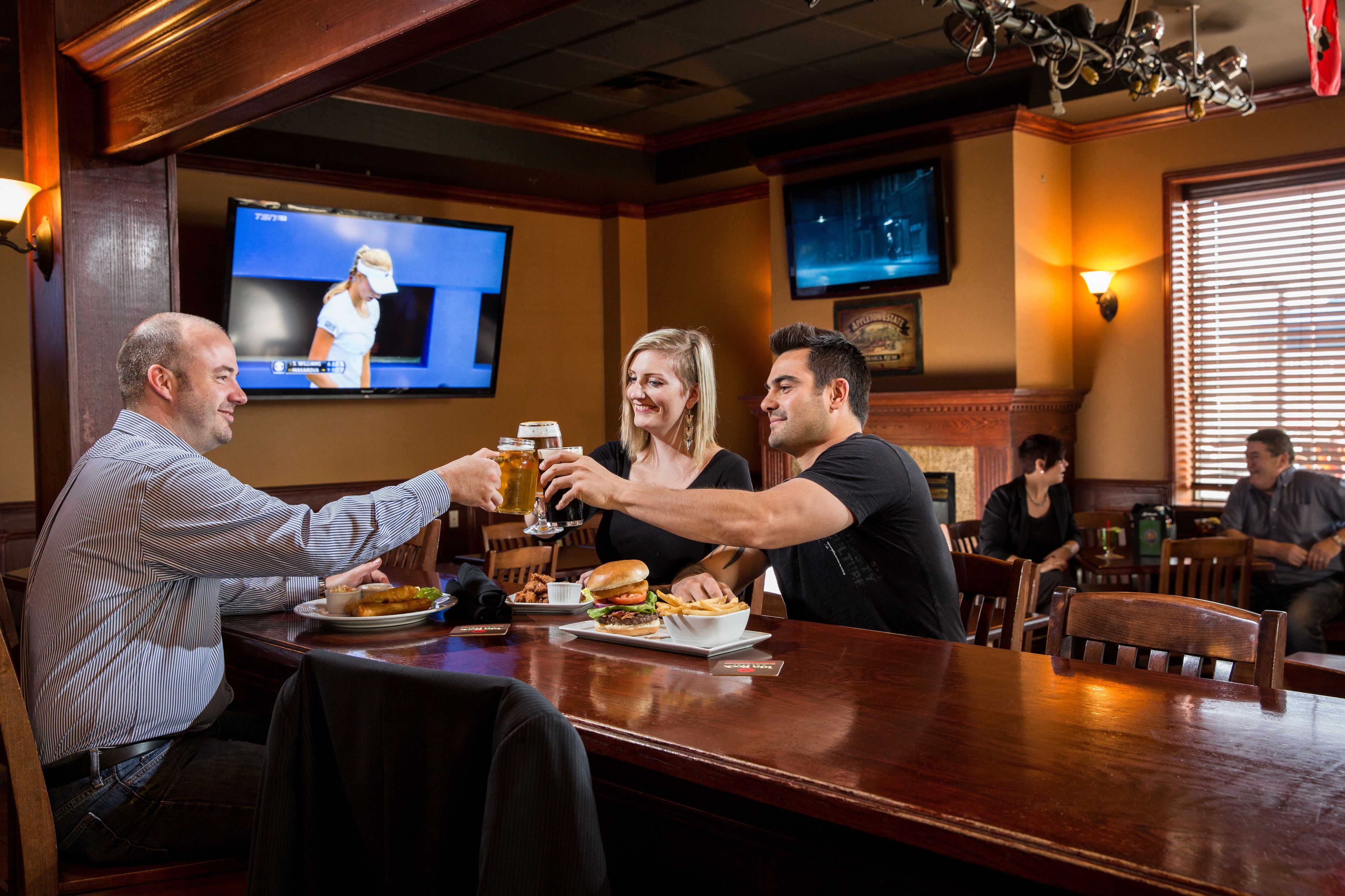 A bar area with wooden furniture, a television screen, and a fireplace.