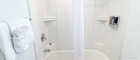 A bathroom with a bathtub, toilet, and shower curtain.