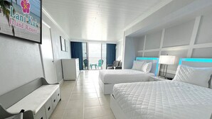 Habitación de hotel con dos camas, un escritorio, una silla y vista a la playa.