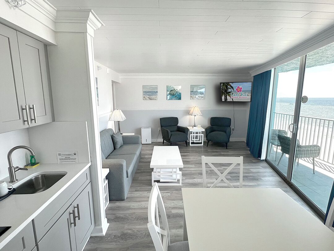 Un interior moderno con cocina, zona de estar y balcón con vistas al mar.