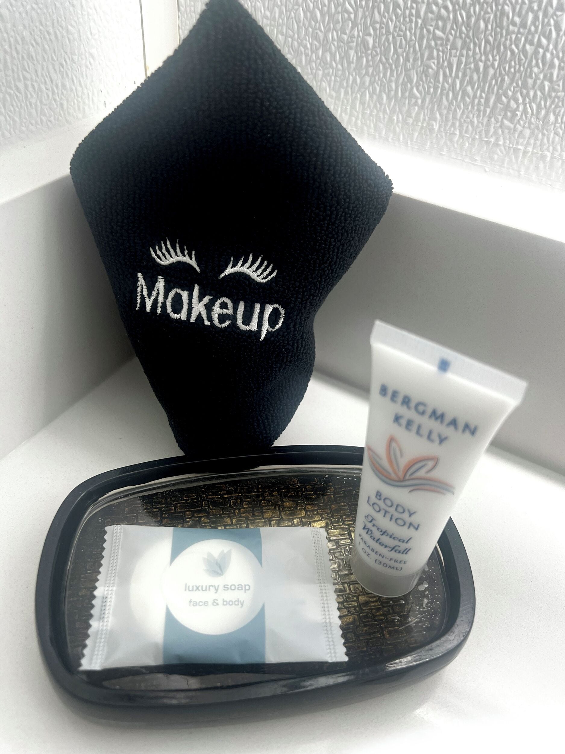 A makeup bag with the word "Makeup" and a tube of Bergman Kelly body lotion.