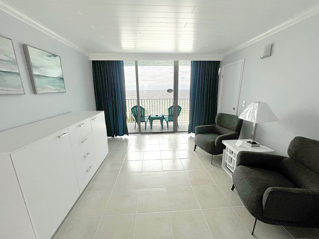 Une chambre moderne avec un balcon, un canapé, une table et un meuble.