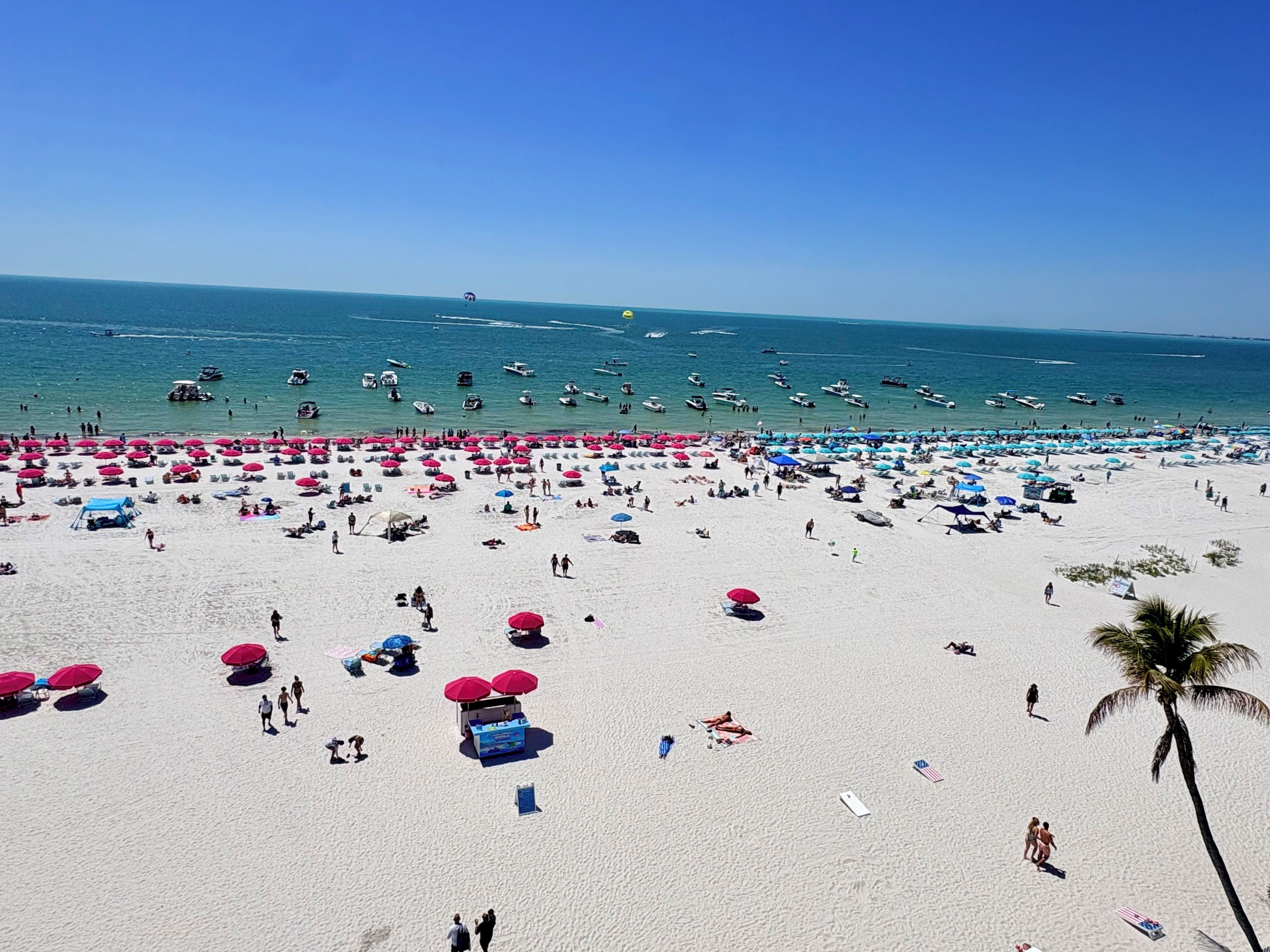 Une plage avec de nombreux parasols et beaucoup de monde.