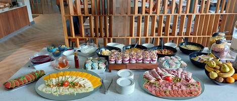 A buffet table with various food items and drinks.