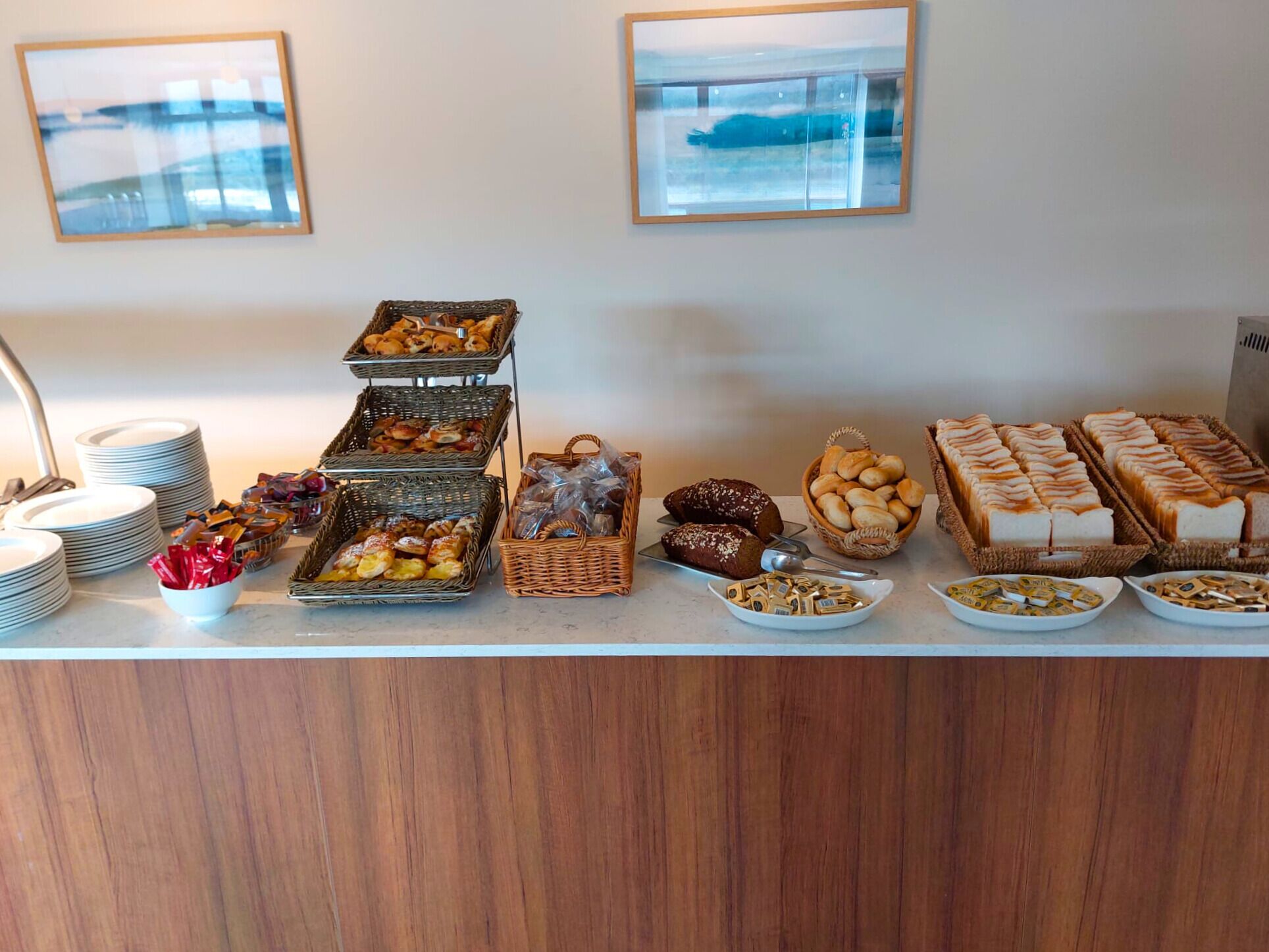 A buffet with various food items and plates arranged on a counter.