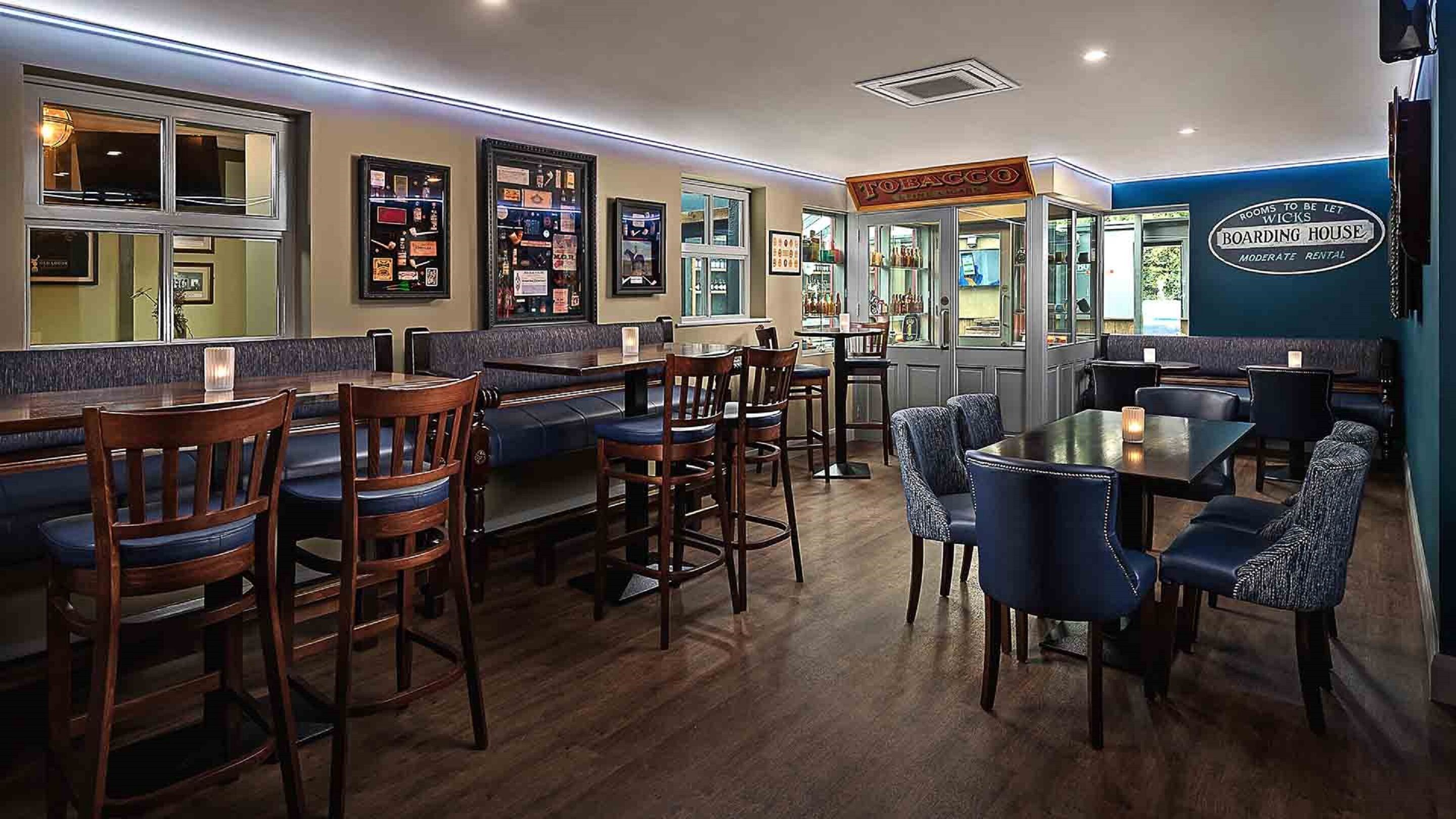A restaurant with booths and tables, a bar area, and a sign for 'Boarding House' indicating moderate rental rooms.