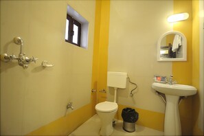 Une salle de bain avec des toilettes, un lavabo et une douche.