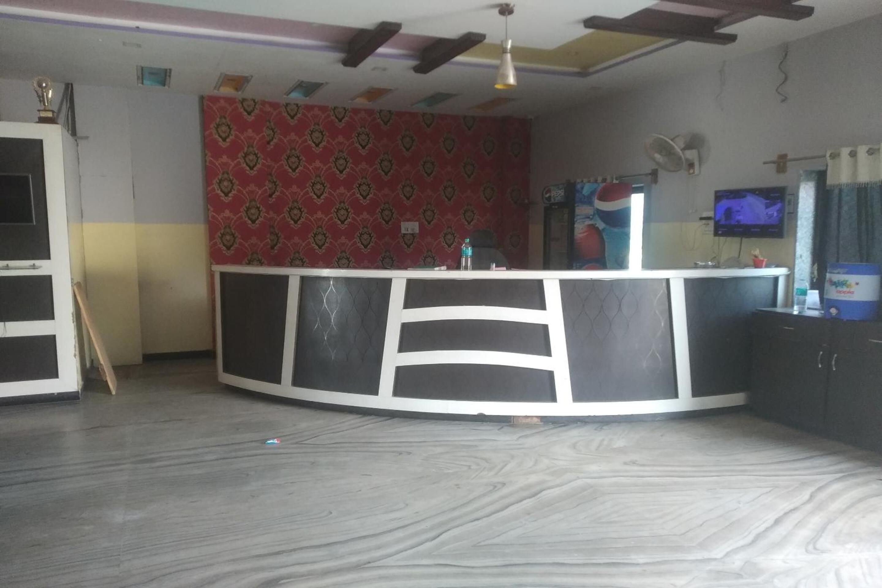 Una cocina con una isla curvada, televisión y un ventilador en la pared.