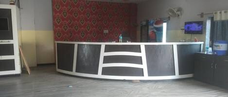 Una cocina con una isla curvada, televisión y un ventilador en la pared.