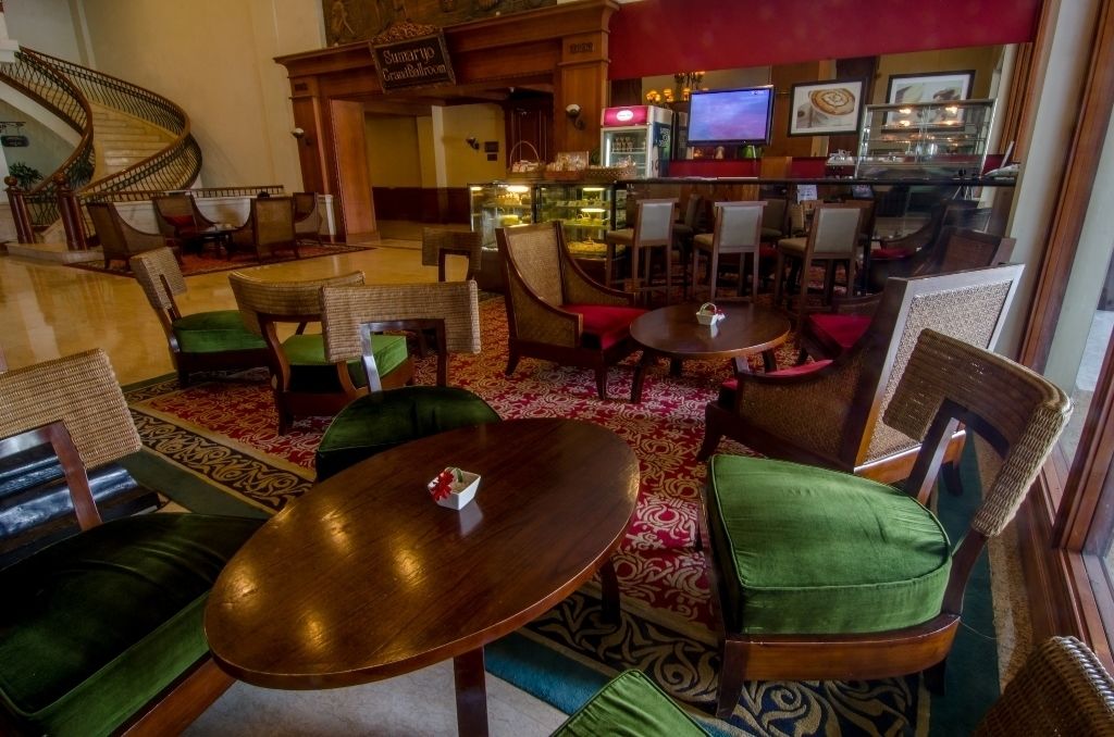 A lobby with a spiral staircase, wooden furniture, and a bar area.