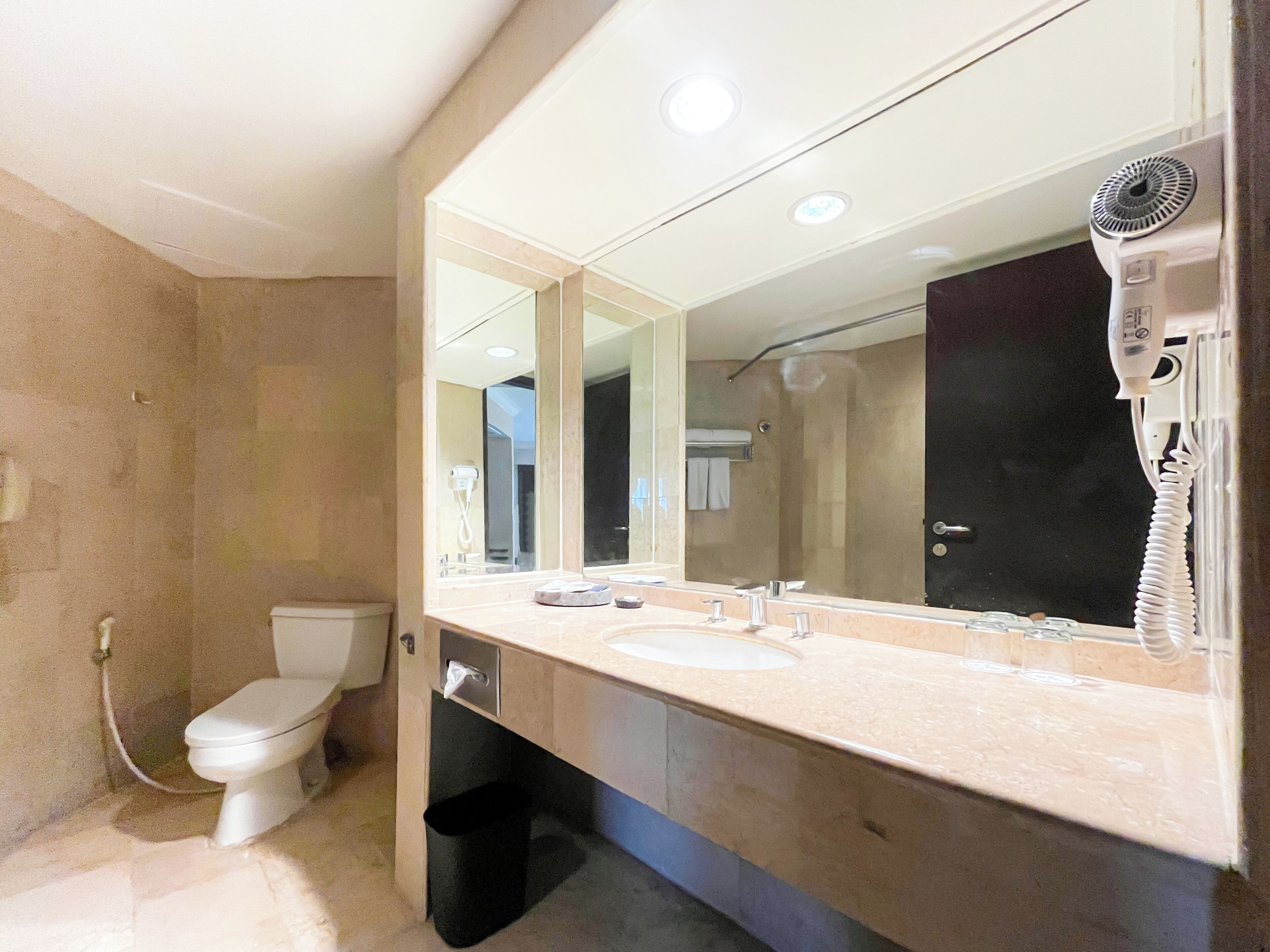 A bathroom with a toilet, sink, and mirror.