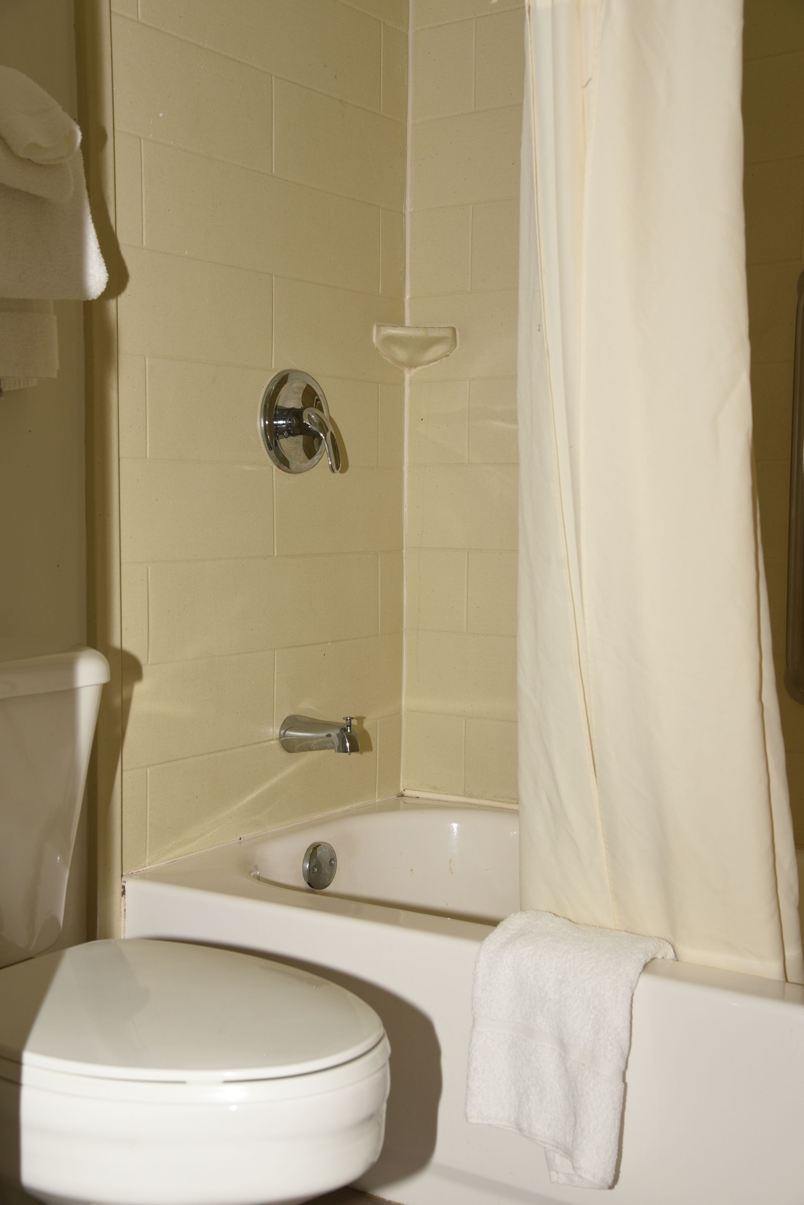Un baño con inodoro, bañera y cortina de ducha.
